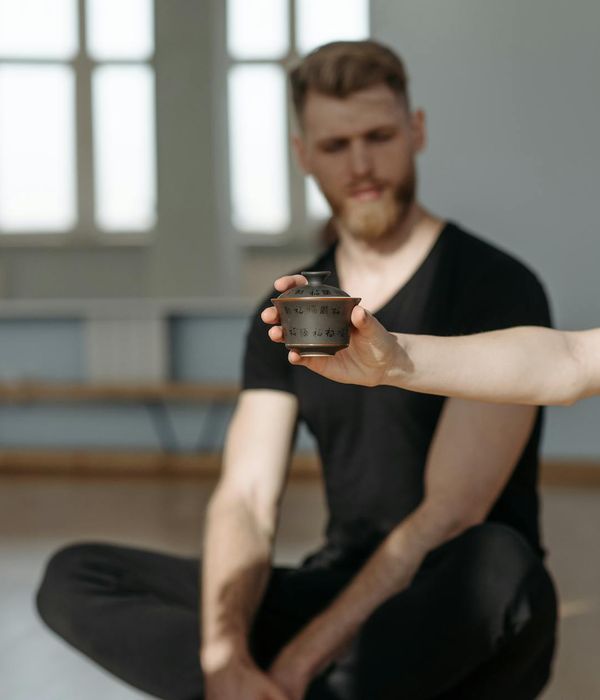 Woman holding a calm yoga pose in a dark, serene environment.